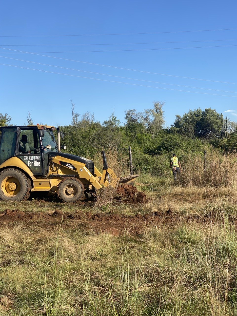 Yellow TLB/backhoe working on Cosmo Peak site clearing
